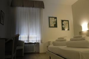 una camera d'albergo con due letti e una finestra di Hotel Roma a Palmanova