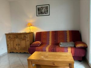 ein Wohnzimmer mit einem Sofa und einem Tisch in der Unterkunft Le petit bonhomme de neige in Gérardmer