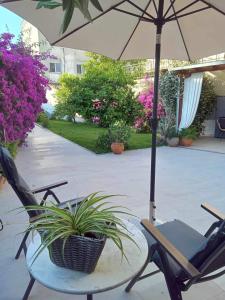 eine Terrasse mit einem Tisch, Stühlen und einem Sonnenschirm in der Unterkunft Alkistis House in Volos
