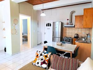 a kitchen with a table and a kitchen with a refrigerator at Family stone apartment in Kyparissia
