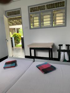 Una cama con dos platos encima y una mesa. en Flexi Lodge, en Negombo