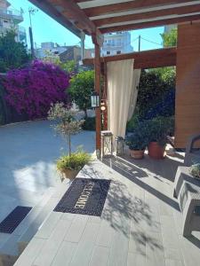 a patio with a pavilion with plants and flowers at Alkistis House in Volos