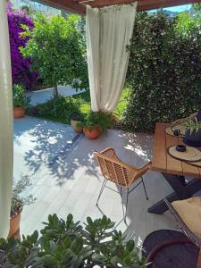 un patio con mesa, sillas y plantas en Alkistis House, en Volos