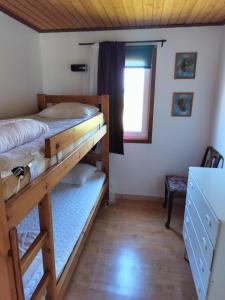 1 Schlafzimmer mit 2 Etagenbetten und einem Fenster in der Unterkunft Svalsjöns Stugor Öland in Köpingsvik