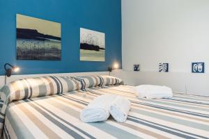 2 camas con toallas en un dormitorio en Appartamento Pet-Friendly Vista Mare Recco, en Recco