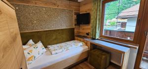 a small room with a bed and a window at Hotel-Garni Pramstraller in Mayrhofen