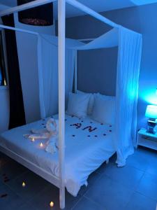 - une chambre avec un lit à baldaquin blanc éclairé dans l'établissement Nid’Ange, à Piolenc