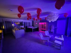 une salle violette avec des ballons, des chaises et des tables dans l'établissement Nid’Ange, à Piolenc