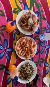 une table avec trois assiettes de denrées alimentaires et de fruits à coque dans l'établissement Flexi Lodge, à Negombo