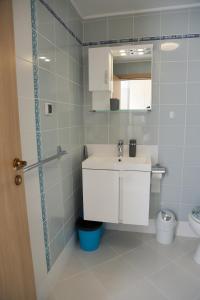 a bathroom with a sink and a mirror and a toilet at Lux Sozopoli Hills Apartments A19 и Studio А13 in Sozopol
