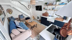 a living room with a couch and a table at AMAZING LOCATION - "SMUGGLERS HIDE" & "SMUGGLERS CABIN" - a 2 BEDROOM FISHERMANS COTTAGE with HARBOUR VIEW and also a private entrance 1 BED STUDIO - 10 Metres To Sea Front - BOOK BOTH for ENTIRE 3 BEDROOM COTTAGE - 2023 GLOBAL REFURBISHMENT AWARD WINNER in St Ives