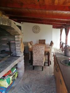 a kitchen with a table and chairs and a clock on the wall at Katun in Vrdnik