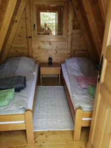 a room with two beds in a log cabin at Katun in Vrdnik