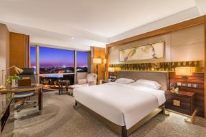 1 dormitorio con 1 cama blanca grande, escritorio y 1 habitación en Lake View Hotel, en Beijing