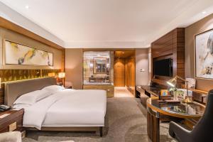 Dormitorio con cama, escritorio y TV en Lake View Hotel, en Beijing