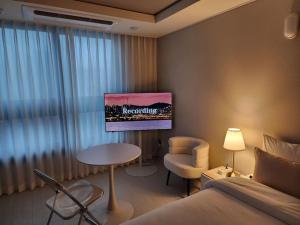 Zimmer mit einem Bett, einem Tisch und einem Stuhl in der Unterkunft 동성로 Residence Daon in Daegu