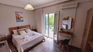 a bedroom with a bed and a mirror and a window at Emilios Eleni studios in Nydri