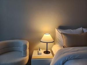 una camera con letto, lampada e sedia di 동성로 Residence Daon a Daegu