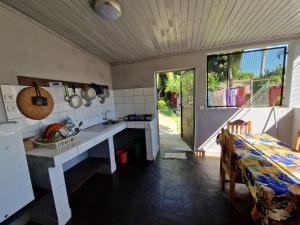 cocina con fregadero y mesa en una habitación en Bungalow Chez Mouch Nosy Be 5, en Nosy Be