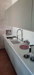 a white kitchen with a sink and a stove at La casa di Giada, villetta indipendente con wi-fi e parcheggio gratuiti in Poggi