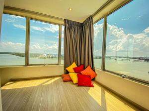 um quarto com janelas com almofadas coloridas no chão em Muar Traders Hotel em Muar