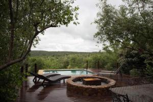 a deck with a fire pit and a swimming pool at Elandsfontein 21, Mabalingwe in Mabula