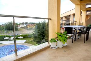a balcony with a view of a pool and a table and chairs at Lux Sozopoli Hills Apartments A19 и Studio А13 in Sozopol