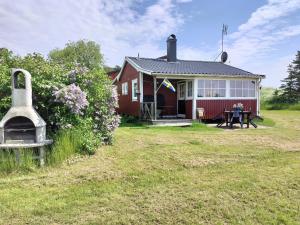 een rood huis met een tafel ervoor bij Svalsjöns Stugor Öland in Köpingsvik
