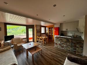 a living room with a couch and a table and a kitchen at Apart Centro Formigal - WOWRURAL in Formigal