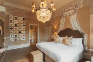 una camera da letto con un letto grande e un lampadario di No 15 by GuestHouse, Bath a Bath