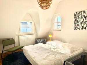 a bedroom with a bed and a chair and a chandelier at Bénodet, superbe maison 5 chambres à 150 m de la plage et restaurants in Bénodet