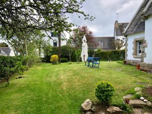 a yard with a umbrella and a table and a chair at Bénodet, superbe maison 5 chambres à 150 m de la plage et restaurants in Bénodet