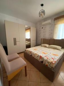 a bedroom with a bed and a chair in it at At-Salaj1 in Vlorë