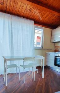 a table and chairs in a kitchen with a window at SantOliva Apartments in Trabia