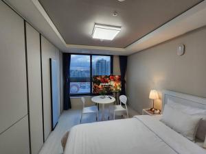 una camera con letto, tavolo e finestra di 동성로 Residence Daon a Daegu