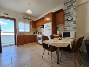 a kitchen with a table and chairs in a kitchen at Holiday House 3- Kallithea Halkidiki in Kallithea Halkidikis