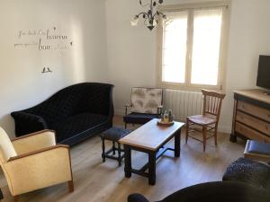 a living room with a couch and chairs and a table at Superbe maison de famille proche du circuit des 24h in Écommoy