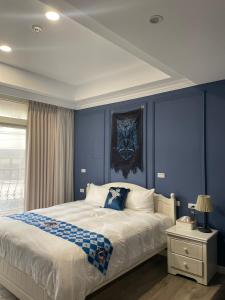 ein Schlafzimmer mit blauen Wänden und einem großen Bett in der Unterkunft 鹿莫思 Lumos in Qingshui