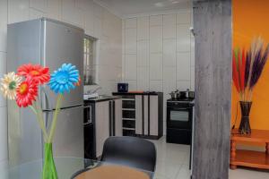 una cucina con tavolo in vetro e vaso con fiori di Elegant Poolside Retreat 2-Bed Luxury Guesthouse a Newcastle