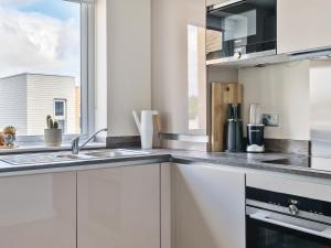 a kitchen with a sink and a window at Spacious Apartment in Addlestone with Free Parking- Pass the Keys in Addlestone