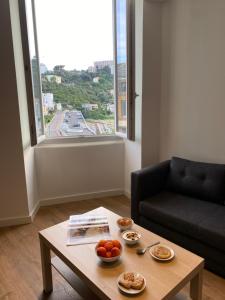 a living room with a table with bowls of fruit on it at Plein Centre Bastia in Bastia