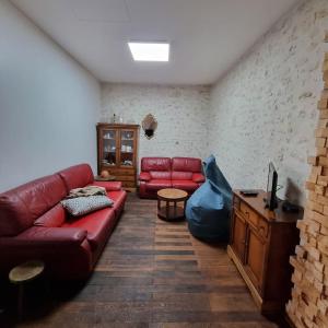ein Wohnzimmer mit einem roten Sofa und einem Fernseher in der Unterkunft Chez Peta - maison familiale rénovée 100m² in Fontaine-le-Comte