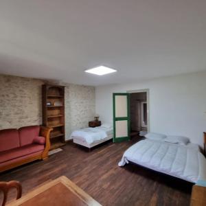 Großes Zimmer mit 2 Betten und einem Sofa in der Unterkunft Chez Peta - maison familiale rénovée 100m² in Fontaine-le-Comte