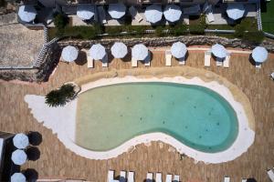 an overhead view of a swimming pool with umbrellas at Baglio Dello Zingaro in Scopello