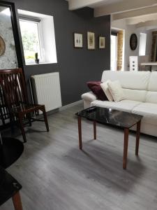 een woonkamer met een witte bank en een salontafel bij Charmante longère en pierres refaite à neuf in Moëlan-sur-Mer