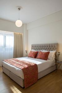 La Residence Athens في أثينا: غرفة نوم بسرير كبير ومخدات حمراء