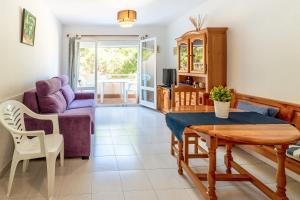 een woonkamer met een tafel en een bank bij Fener de Dalt 84 apartamento piscina comunitaria in Llança