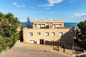een huis op een heuvel met de oceaan op de achtergrond bij Fener de Dalt 84 apartamento piscina comunitaria in Llança
