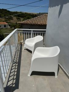 2 sillas blancas en la parte superior de un balcón en Mary's Apartment, en Romanón