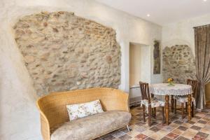 ein Wohnzimmer mit einer Steinmauer, einem Sofa und einem Tisch in der Unterkunft Country Agritur Tenuta Corte Tese in Sona